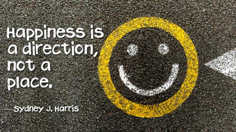pavement with smiley face painted on it and happiness quote