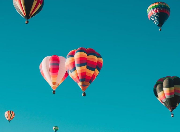 Several hot air balloons in a clear sky.