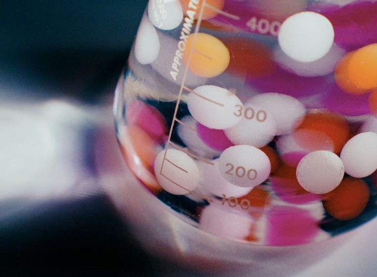 Colorful balls suspended in a solution in a lab beaker.