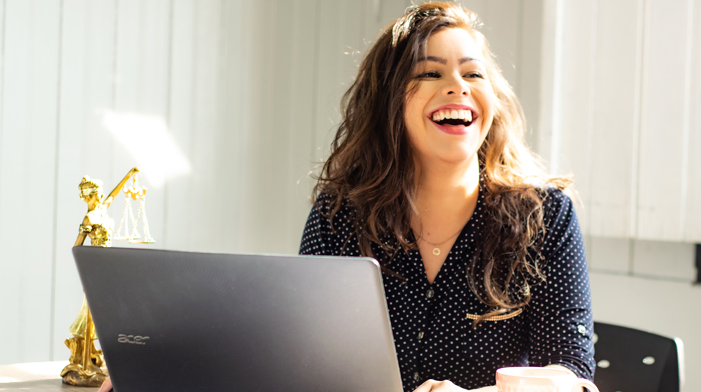 woman in front of computer smiiling