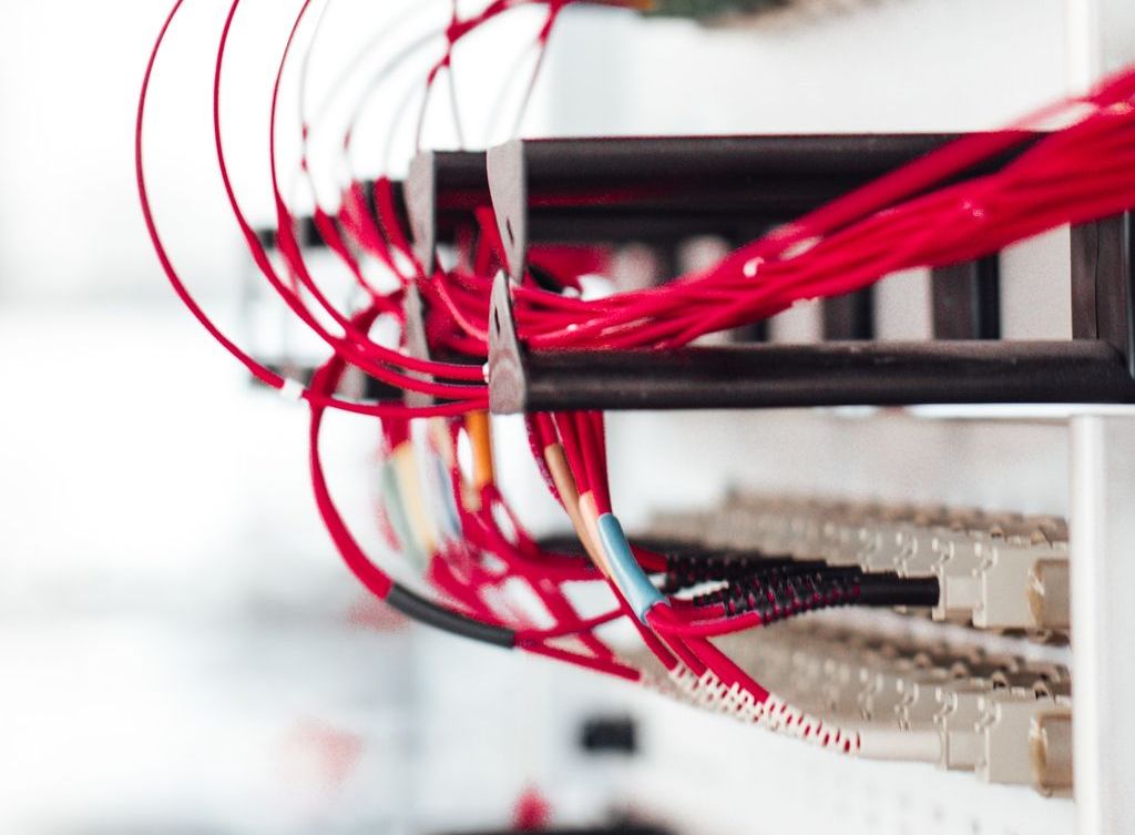 A server rack with red ethernet cables.