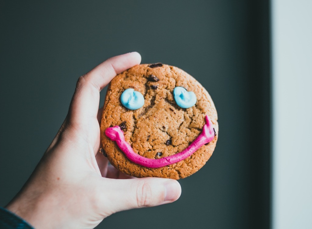 A cookie frosted with a smiling face.