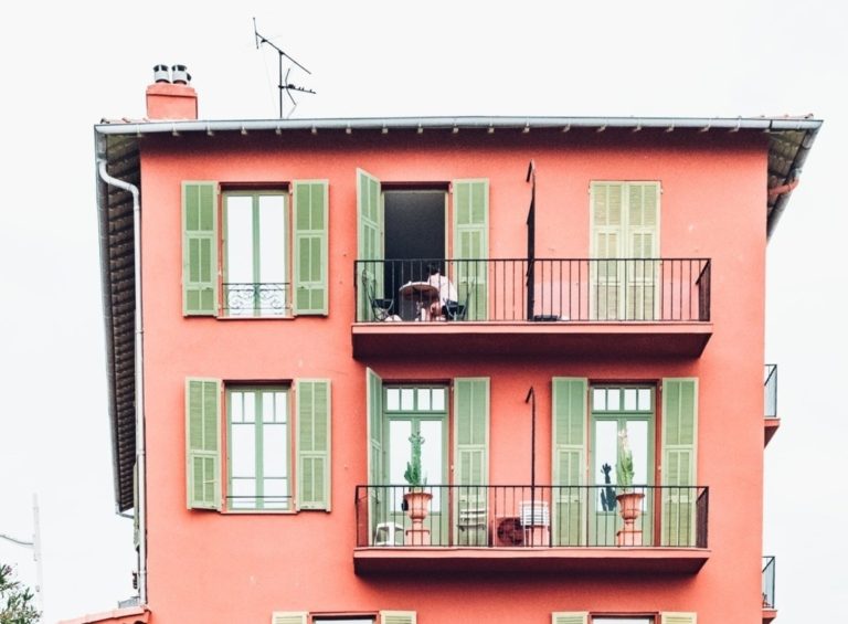 An apartment building with two balconies, one above the other.