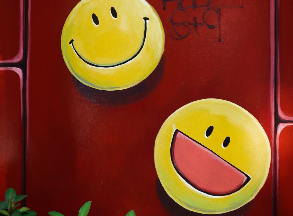 Two smiley faces on a wall.